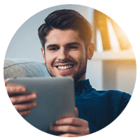 Man smiling when looking at his tablet