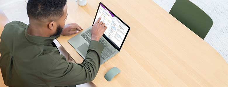 A man works on a Microsoft Surface laptop