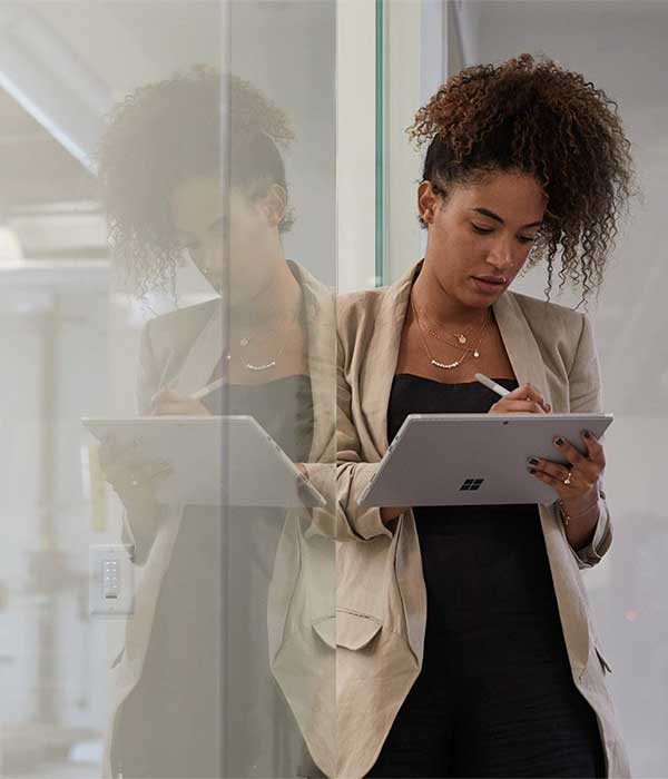 A businesswoman works at a Surface Pro 7+