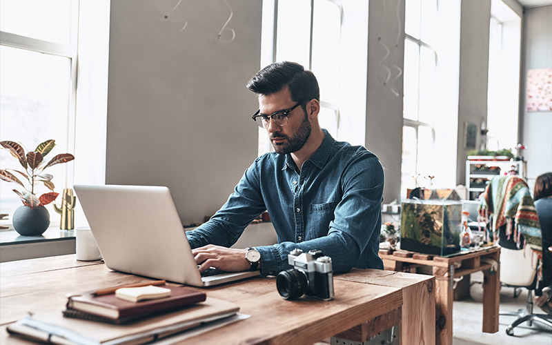 Casually dressed man working on a laptop