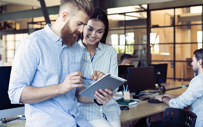 Two colleagues sharing a tablet in a meeting