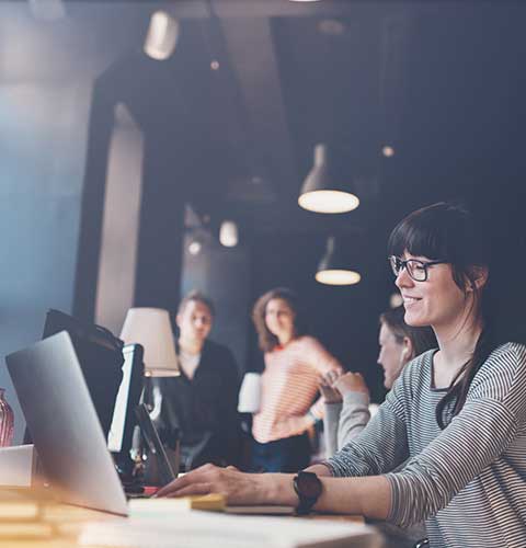 Happy employee working on laptop