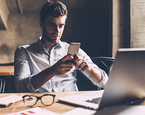 Man wearing a shirt looking at his smartphone