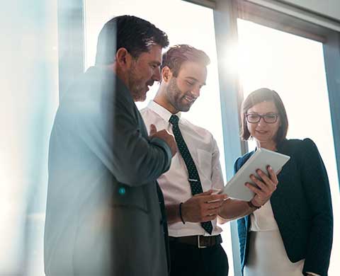 Group of people looking down at a tablet