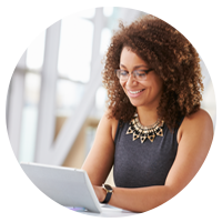 Smiling woman works on her laptop