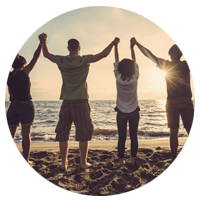 Group of happy people jumping on beach at sunset