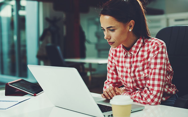Protect the digital life of your users woman working on a laptop with a cup of coffee
